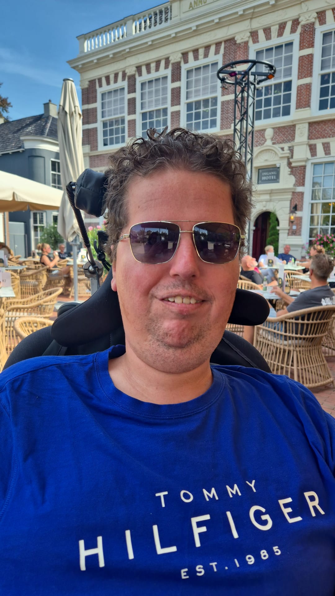 Germ Knol op een zonnig terras, met een blauw shirt en zonnebril